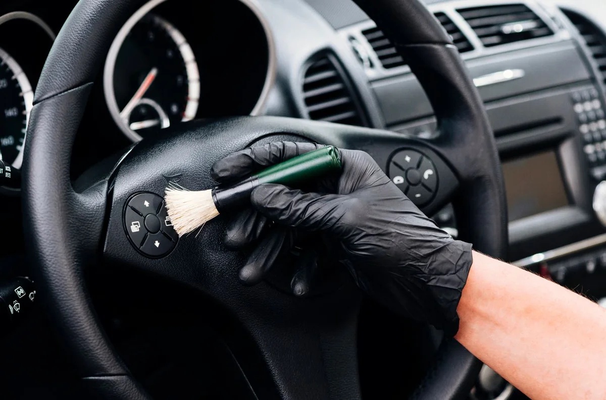 Curățarea volanului auto cu o perie, pentru prezentarea pachetului Detailing PLUS